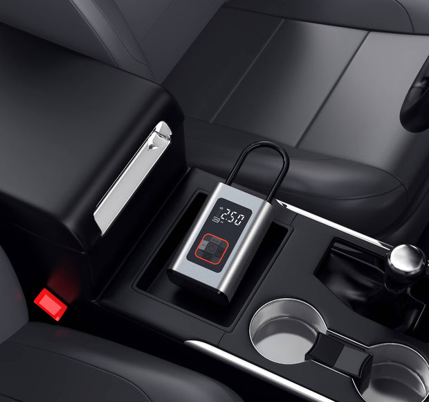 Digital tire inflator with LED display placed in a car console, showcasing a modern and compact design.