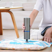 Person using a mini car vacuum cleaner on a cushion to remove dirt and debris, showcasing its compact design.