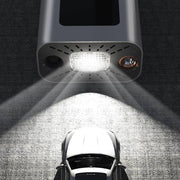 Top view of a portable tire inflator with bright LED light illuminating a parked car.
