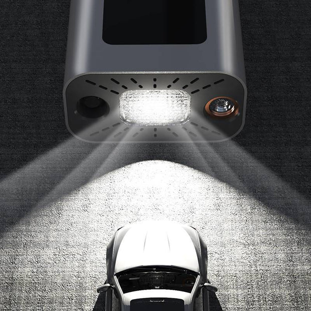 Top view of a portable tire inflator with bright LED light illuminating a parked car.